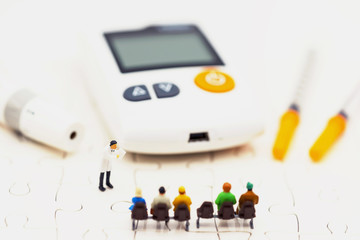 Miniature people: Doctors standing with glucose meter of diabetes  and injection needle , business and health care concept.