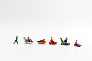 Miniature people: Childrens playing fun with snow slider.