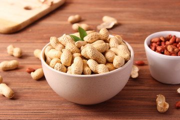raw peanuts in shell on a wooden background.