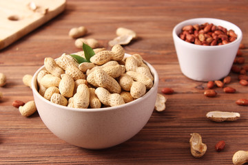 raw peanuts in shell on a wooden background.