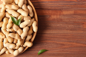 raw peanuts in shell on a wooden background.