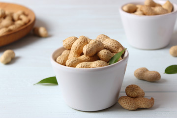 raw peanuts in shell on a wooden background.