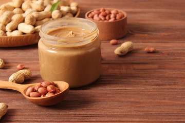  peanut butter and peanut beans on wooden background