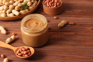  peanut butter and peanut beans on wooden background