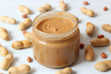  peanut butter and peanut beans on wooden background