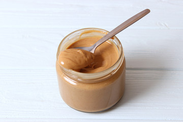  peanut butter and peanut beans on wooden background