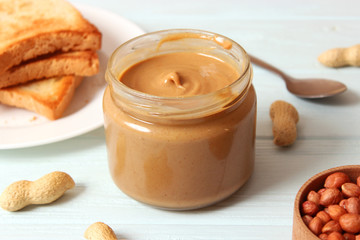  peanut butter and peanut beans on wooden background