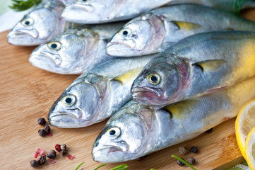 Obraz premium Fresh fish with the vegetables, condiment and lemon, bluefish. Food preparation. 