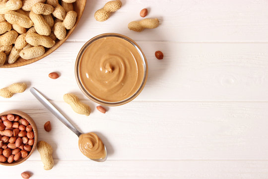  peanut butter and peanut beans on wooden background