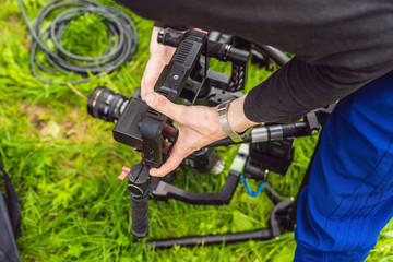 Cameraman setting up heavy duty professional 3-axis gimbal stabilizer for cinema camera