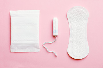 women intimate hygiene products - sanitary pads and tampon on pink background - obrazy, fototapety, plakaty