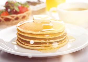 Stack of Small pancakes in syrup on background