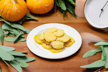 Dish of potatoes with meat on a plate on the table