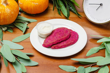 Beet cutlets with sauce in a white plate on the table