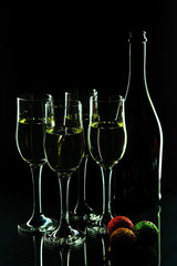 Four glasses of champagne and bottle on a black background