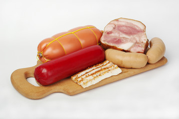 Ham, sausage, bacon on kitchen board