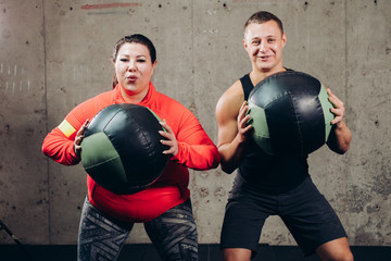 emotional positive couple doing exercises with balls in the fitness center. close up photo. active life