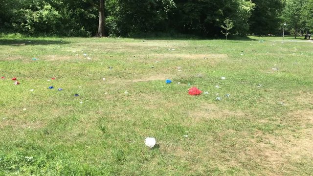 People scattered trash and garbage everywhere in the public park Hasenheide / Bunnyheap after street festival Karneval der Kulturen.