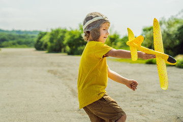 Happy kid playing with toy airplane against old runway background. Traveling with kids concept