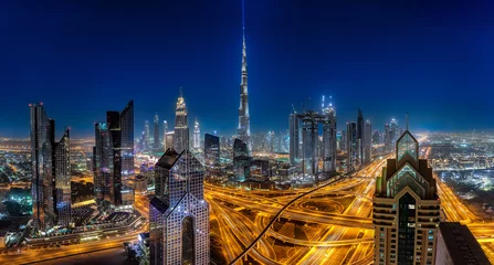 Tuinposter Panoramablick auf die hell beleuchtete Skyline von Dubai bei Nacht © moofushi