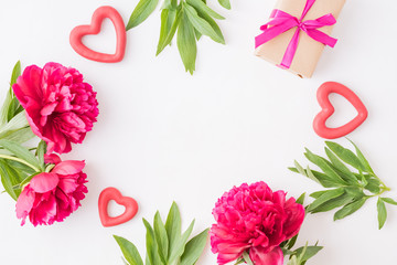 Valentines day composition with red peonies and hearts on a light background