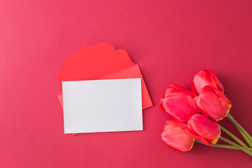 Mockup white greeting card and envelope with red tulips on a red background