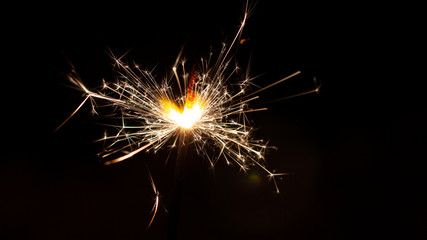 Fototapeta premium Christmas sparkler isolated on black background. Bengal fire