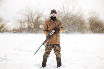 awesome guy with an old gun standing outdoors. full length shot.