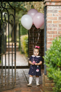 Little Toddler Girl With Pink Birthday Balloons Outside