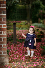 Little Girl in Navy Dress on a pink flowered walkway