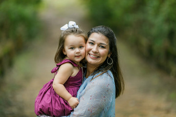 Mom holding preschool toddler daughter girl with strong bond and love