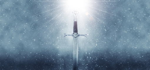 mysterious and magical photo of silver sword over gothic snowy black background. Medieval period...