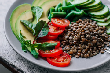 Healthy vegetarian food lentils, avocados, tomatoes, cucumbers, green beans 