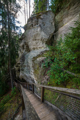 tourist trail with wooden pathwalk and stairs near sandstone cliffs