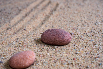 Fototapeta na wymiar relaxing stones laying on sand textured pattern