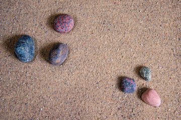 relaxing stones laying on sand textured pattern