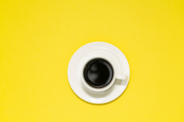 Top view image of coffee cup on yellow background. Flat lay. Copy space