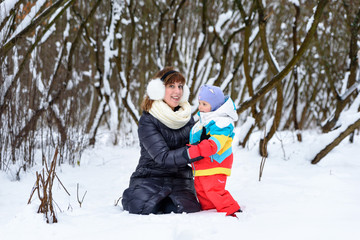 Fototapeta na wymiar family walk in the winter forest dad mom and child
