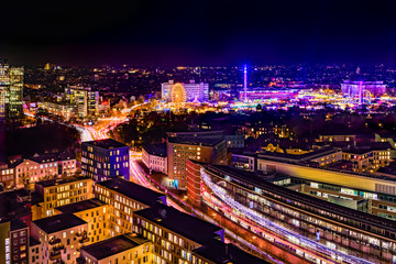 Fototapeta na wymiar Aerial view of downtown Hamburg, Germany, and the famous funfair (German: Hamburger Dom), illuminated at night.