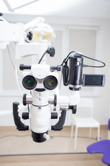 Image of a professional dental endodontic binocular microscope with a camera in the treatment room 