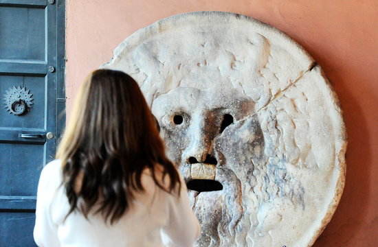 Beautiful asian women photograph each other in front of the mouth of truth (Bocca della Verit&agrave;). Church of Santa Maria in Cosmedin in Rome, Italy