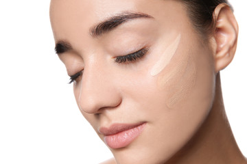 Obraz premium Young woman with different shades of skin foundation on her face against white background