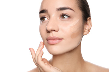 Obraz premium Young woman with different shades of skin foundation on her face against white background