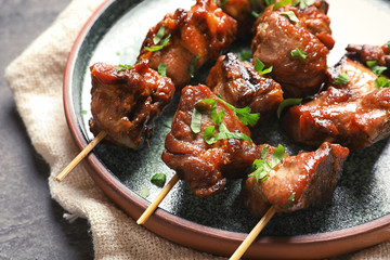 Plate with delicious meat served for barbecue party on gray table, closeup