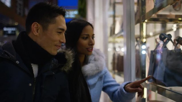 Young mixed race couple window shopping together 
