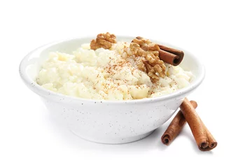 Poster Creamy rice pudding with cinnamon and walnuts in bowl on white background © New Africa