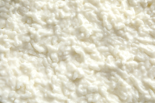 Delicious creamy rice pudding as background, top view