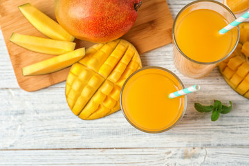 Tasty mango drink and fresh fruits on wooden table, top view