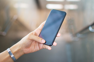 woman's hand holding smart phone with blur background. selective focus and soft focus.