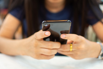 woman's hand holding smart phone with blur background. selective focus and soft focus.